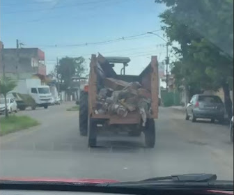 Flagrante de trator transportando caixão no meio de entulho em rua de Três Corações MG - Crítica ao descaso com o IPTU.